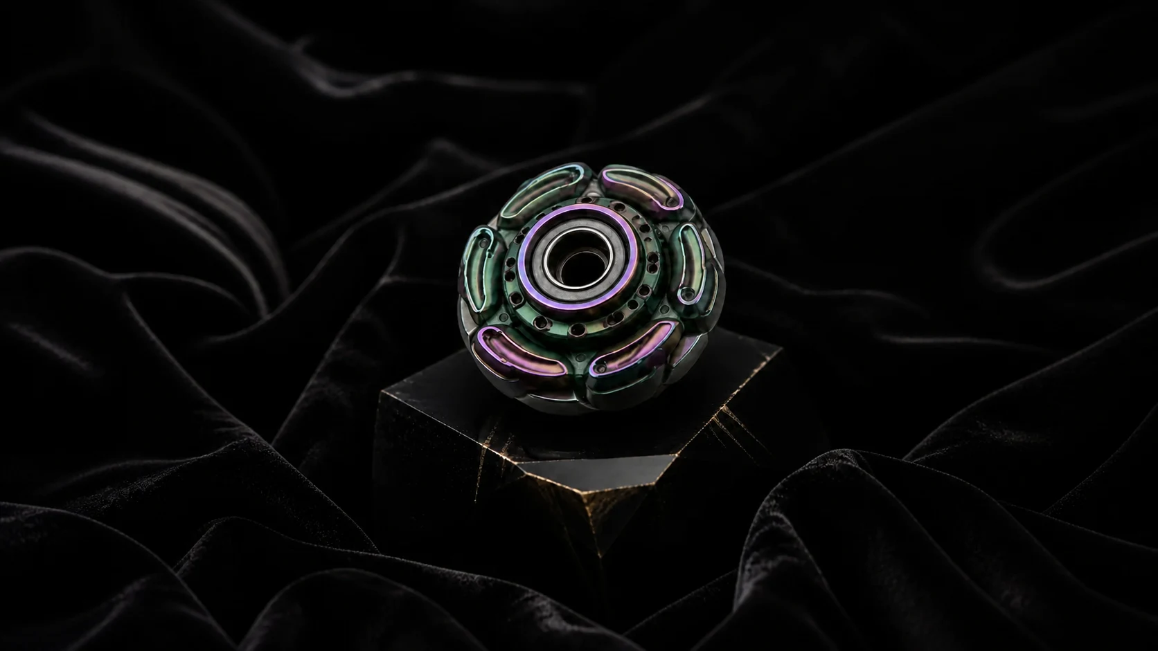 VORTX I iridescent six-lobed spinning object on black velvet and obsidian